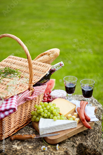 Stylish picnic with red wine, fruit and cheese