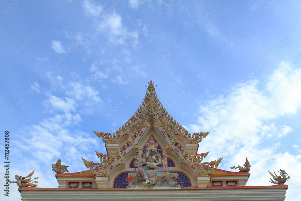 Wat Pariwat Temple showed imeginary king of god statue at church gable with blue sky background