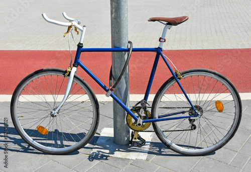 Bicycle chained to a metal pole