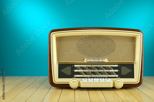 Retro radio receiver on wooden table blue background 3d