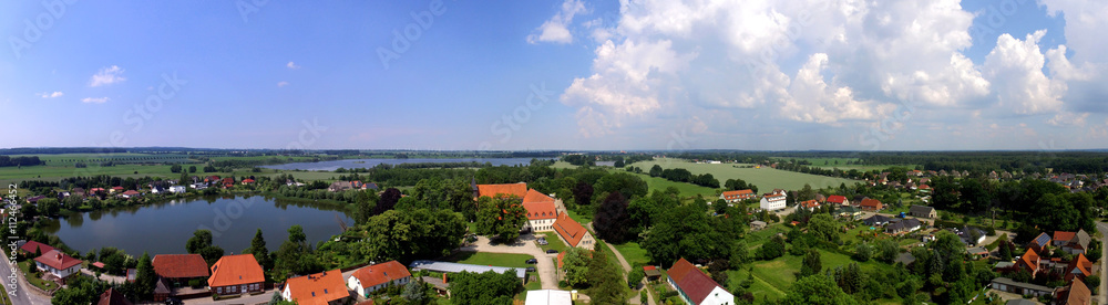 Aerial view panorama of a rural village with lake in Germany