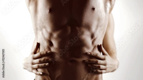 Hands of young woman touching athletic torso with abs of man. Graded