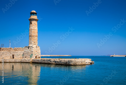 Lighthouse and wall at old Venetian harbour in Rethymno Crete Gr
