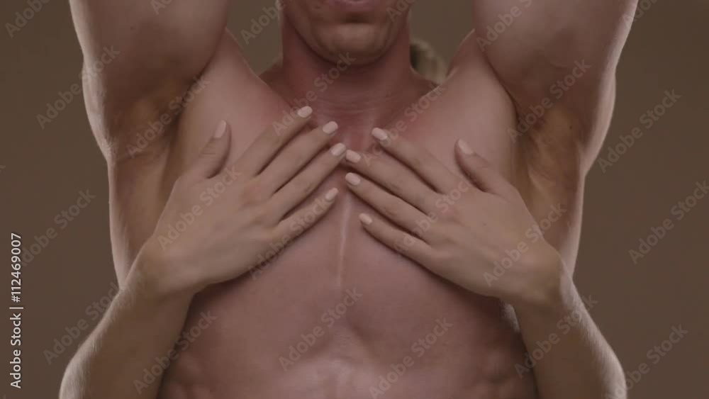 Hands of young woman touching athletic torso with abs of man. Ungraded Hands of young woman touching athletic torso with abs of man. Ungraded