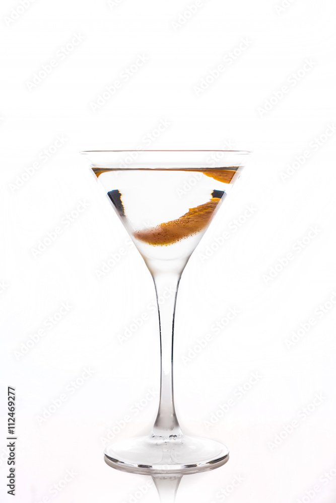 Cocktail with slice of orange zest in martini glass