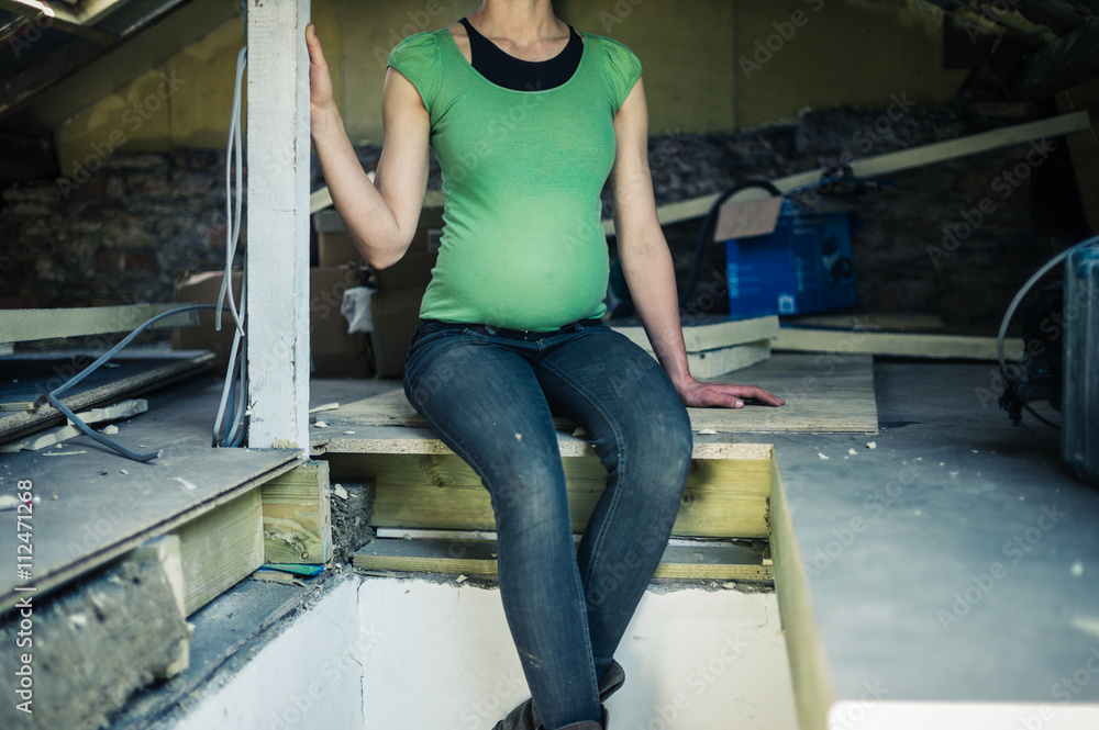 Pregnant woman sitting in attic Pregnant woman sitting in attic