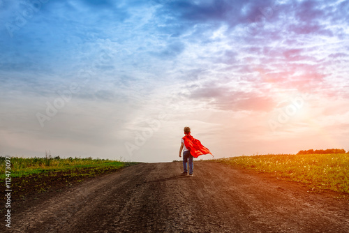 the little preschool boy, plays the superhero outdoors