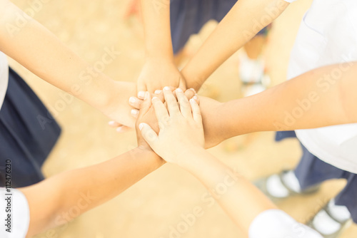 Children making pile of hands ,teamwork concept