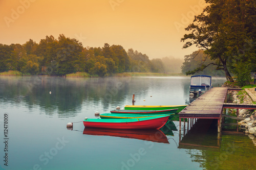 Fototapeta Naklejka Na Ścianę i Meble -  Autumn misty early morning. Wooden boats on the river bank