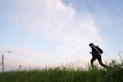 草原を走る男性