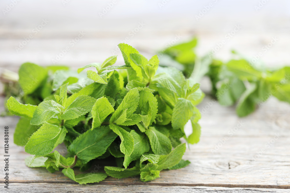 Fresh mint leafs on grey wooden table Fresh mint leafs on grey wooden table