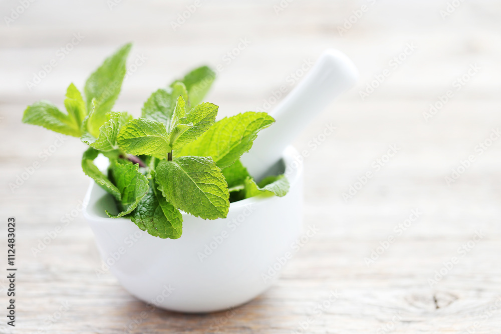 Fresh mint leafs on grey wooden table