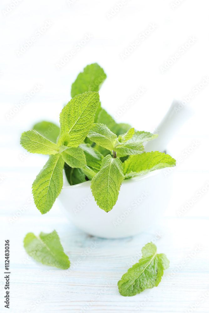 Fresh mint leafs on white wooden table Fresh mint leafs on white wooden table