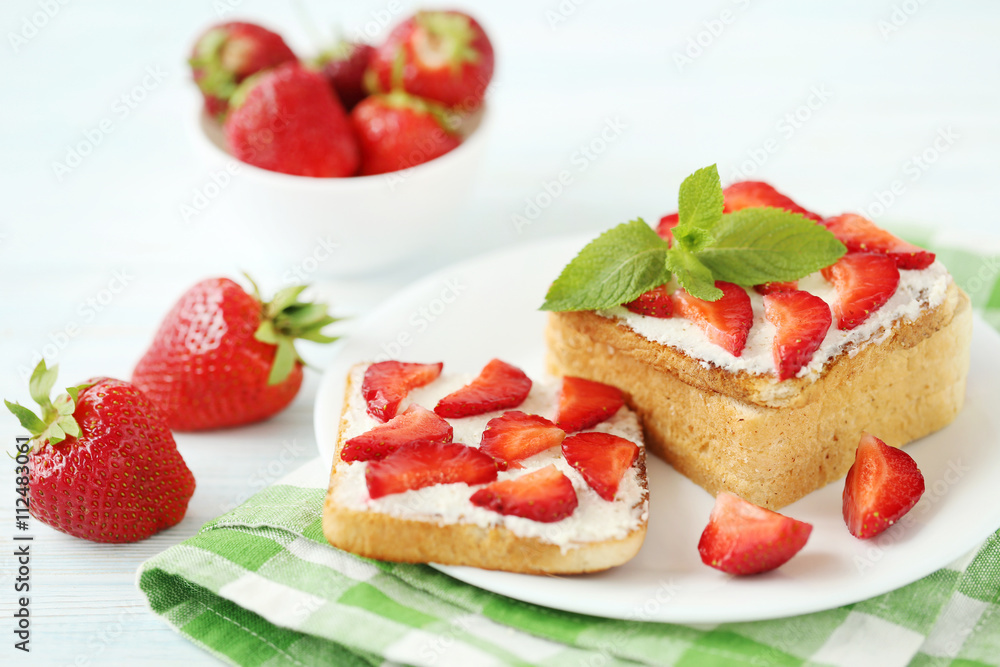 French toasts with cream cheese and strawberry on wooden table French toasts with cream cheese and strawberry on wooden table
