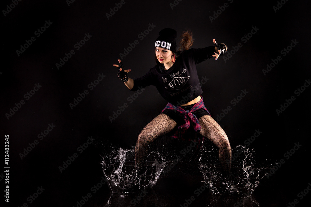 Fototapeta premium beautiful girl in the style of hip-hop jumping in aqua studio