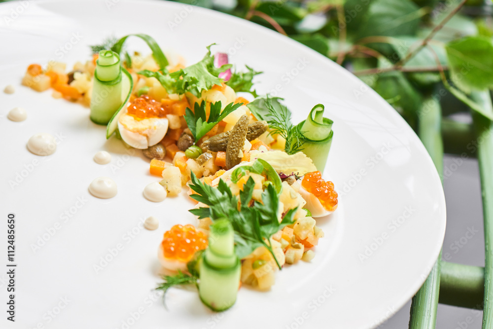 Healthy tomorrow of Russian salad served on a white plate Healthy tomorrow of Russian salad served on a white plate