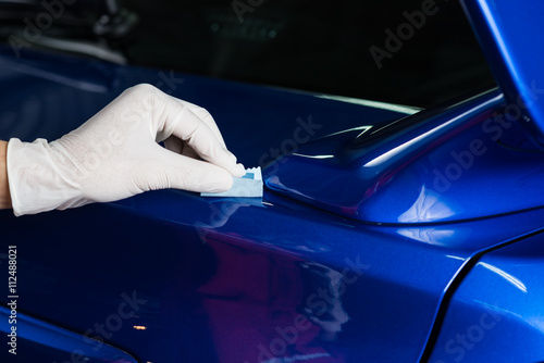 Car detailing series : Closeup of hand coating blue car trunk