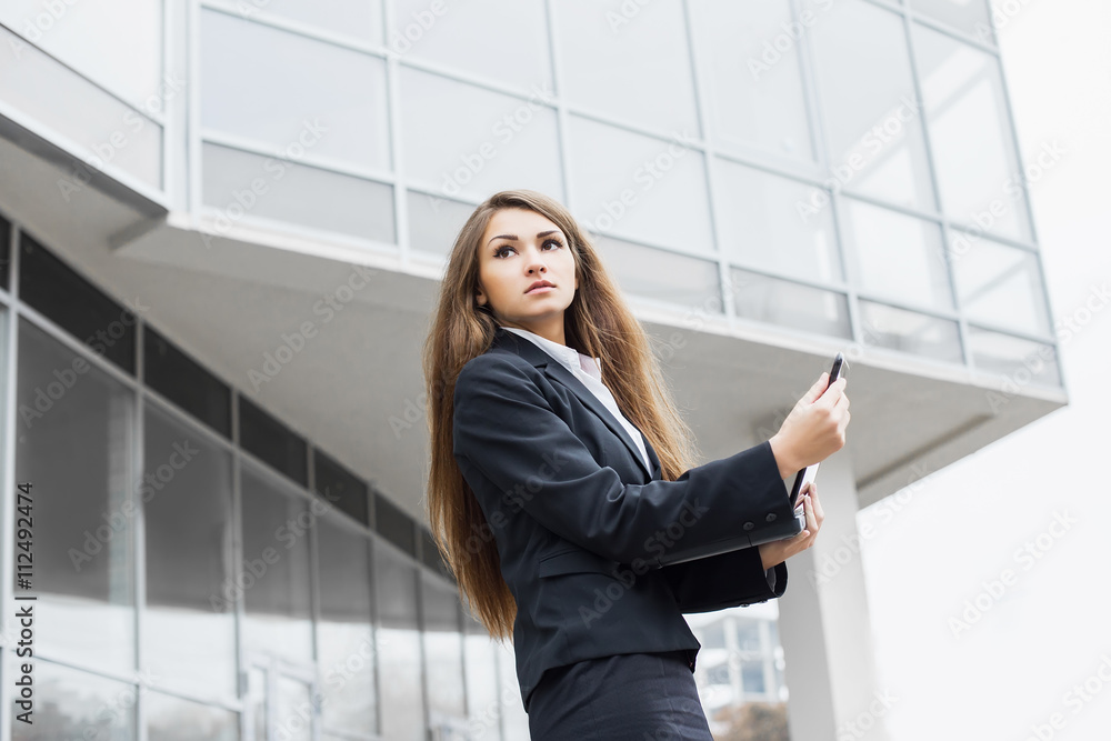 Successful businesswoman or entrepreneur using a laptop, standin Successful businesswoman or entrepreneur using a laptop, standin