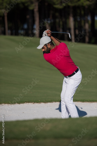 golfer hitting a sand bunker shot