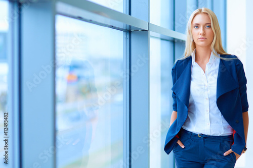 Free Download Young businesswoman standing in business center - GFXLoad