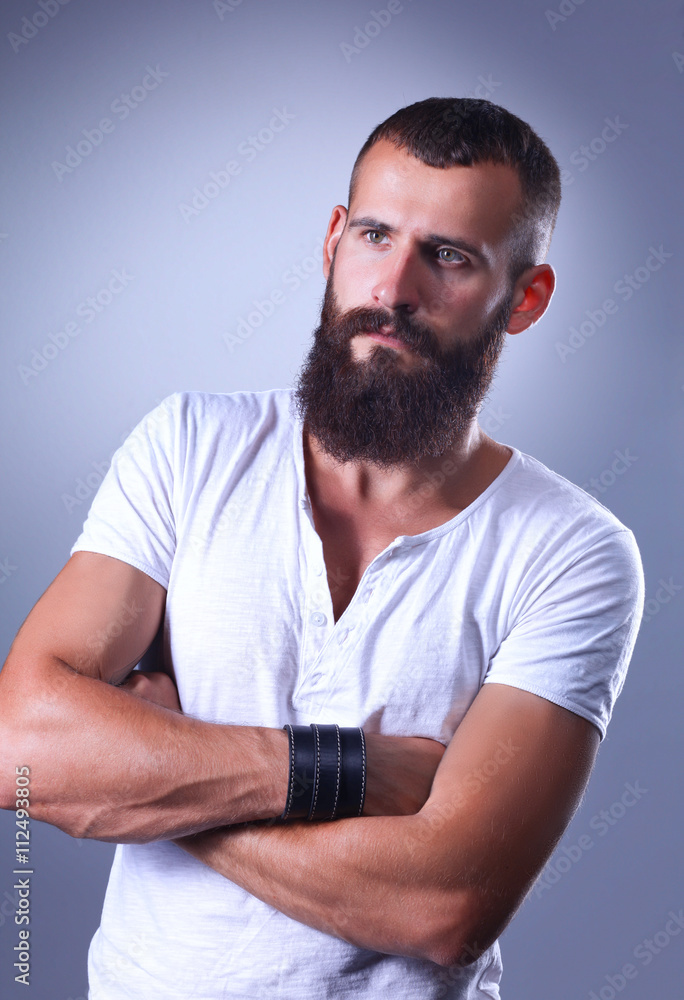 Portrait of handsome man standing, isolated on grey background