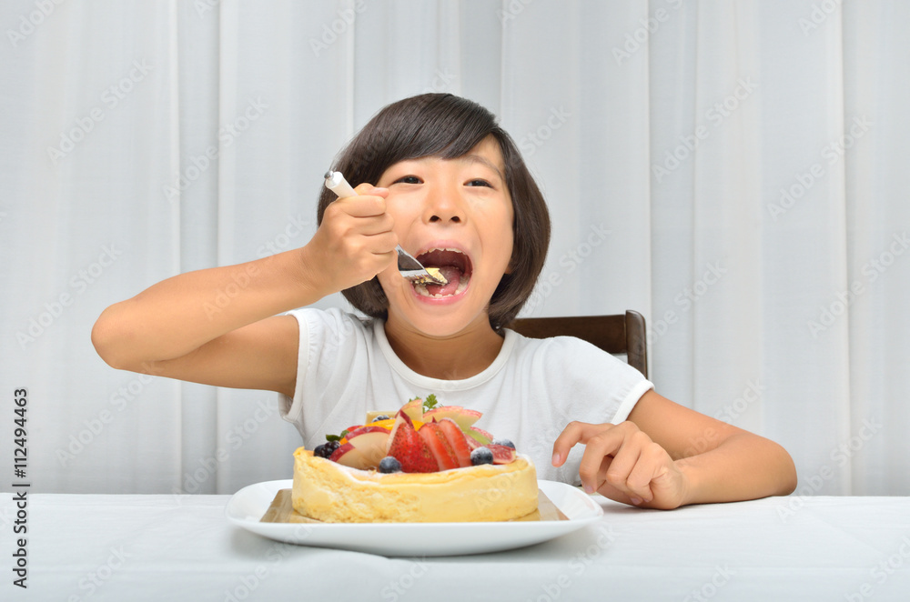 デコレーションケーキを美味しそうに食べる女の子