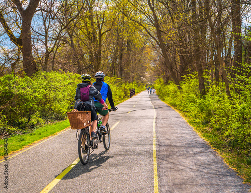 Fotografie Family ride bikes on city urban bike path with dog in basket