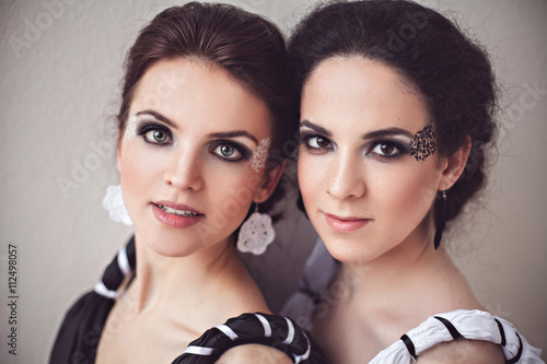 Two sisters with black and white fantasy make-up photo