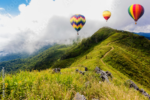 Colorful hot-air balloons flying over the mountain at Pha Tung,Chiangrai province ,North of Thailand.