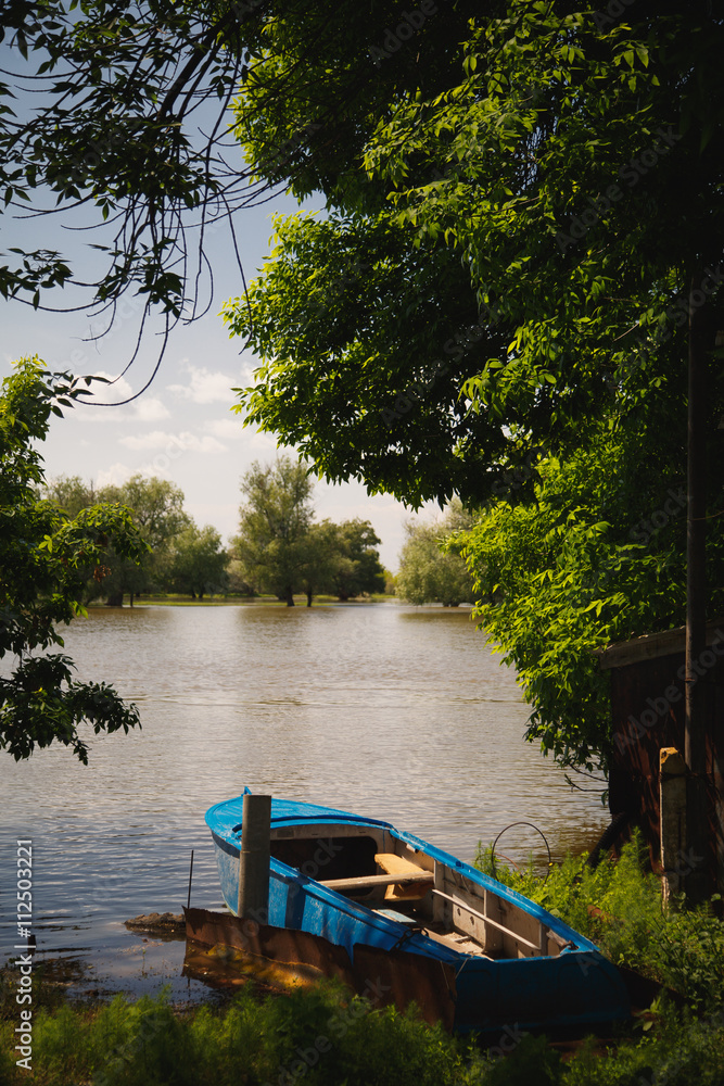 a blue boat moored to the banks of the river a blue boat moored to the banks of the river