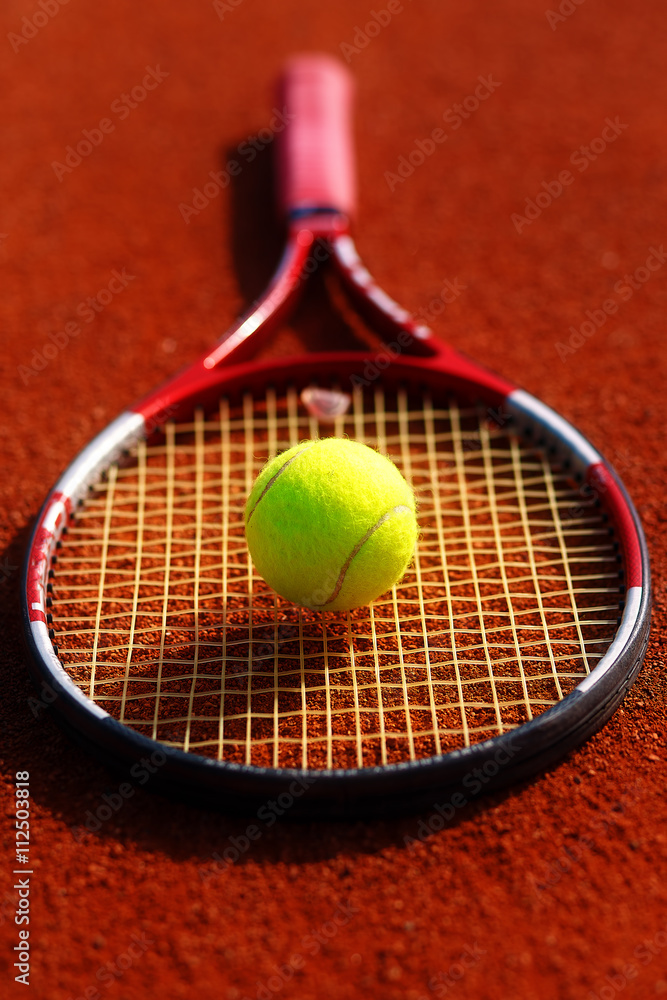 Tennis ball and racket on the court.