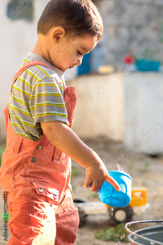 little boy plays with water