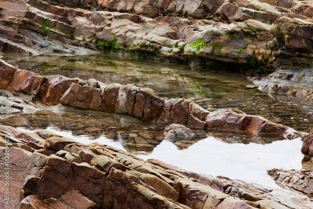 Water left stranded in the rocks by low tide Water left stranded in the rocks by low tide