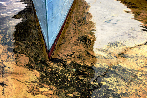 Oil spill from the ship - Texture of crude oil spill on the water. photo