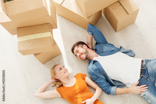 Cute couple lying on floor in their new home