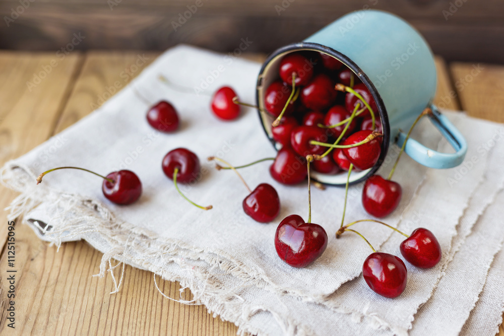 Fresh juicy sweet cherries in old rusty mug. Rustic background with homespun napkin. Fresh juicy sweet cherries in old rusty mug. Rustic background with homespun napkin.