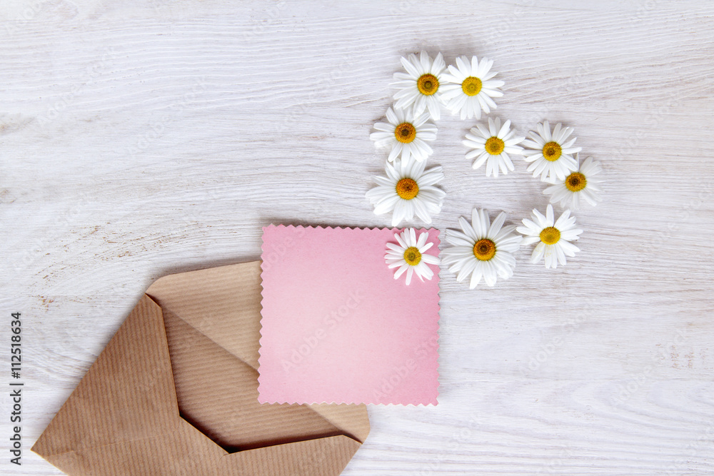  letter with the symbol of flowers heart / flat lay, with pink flowers daisies postcard for clean inscriptions peeping out of the envelope, top view