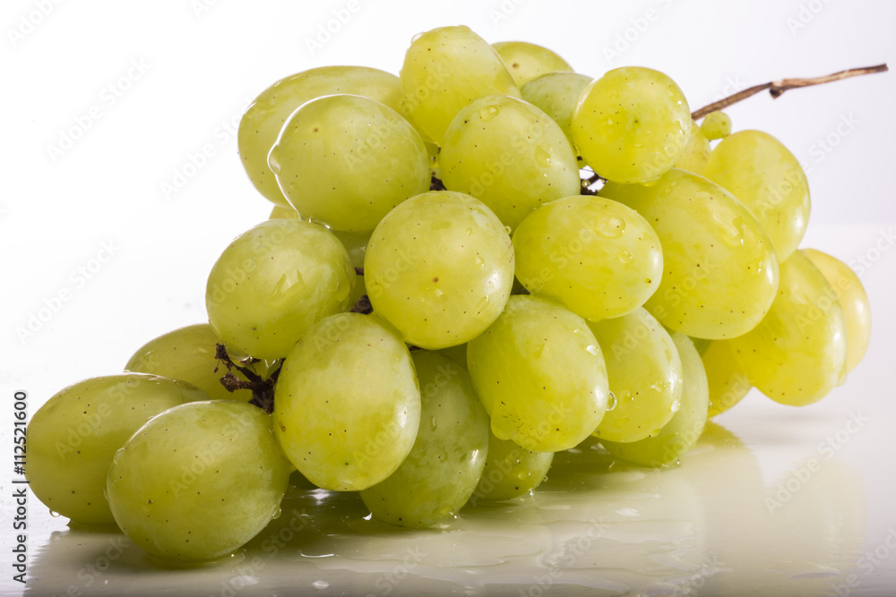 Grapes against a white background on white table.