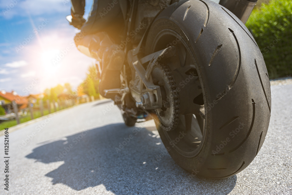 Fototapeta premium On the road-biker and his motorbike driving into the evening sun
