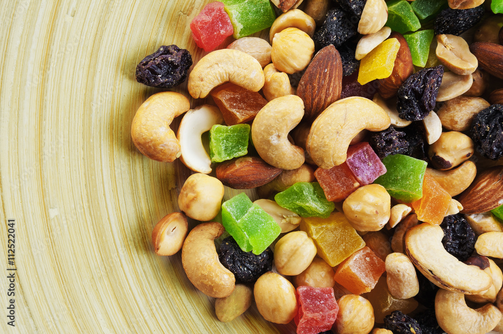 Almonds, cashews and peanuts and dried fruit on wooden plate Almonds, cashews and peanuts and dried fruit on wooden plate