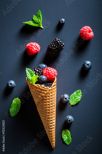 Ice cream with berry fruits in cone as a concept