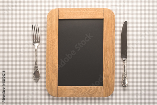 Blackboard for menu with fork and knife on a table