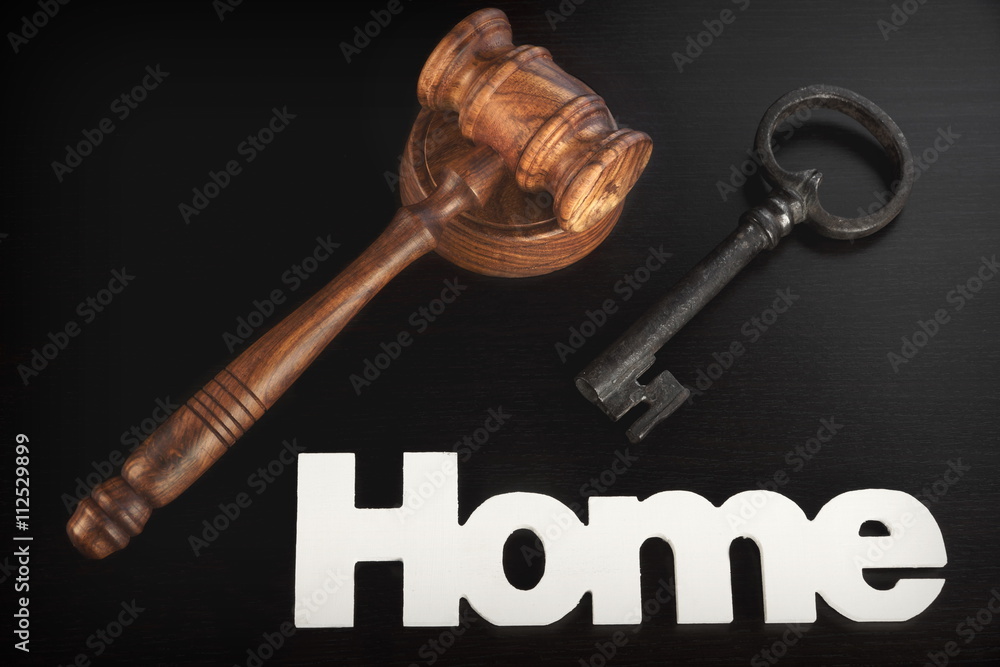 Judges Hammer or Gavel With Home Sign On Dark Background Judges Hammer or Gavel With Home Sign On Dark Background