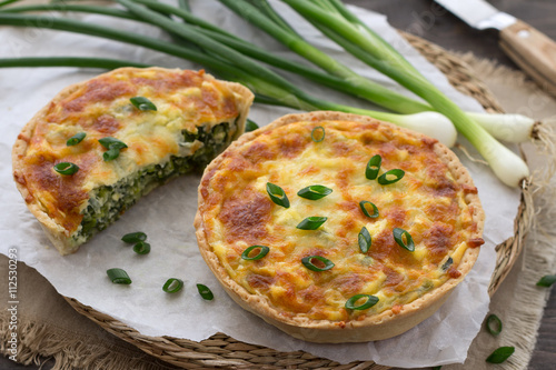 Mini quiche with green onions and cheese on a wooden background 