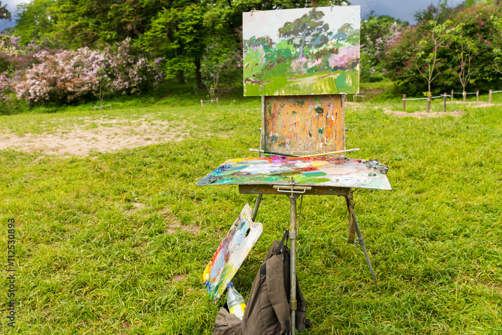 Painter's sketchbook on the tripod in a garden Painter's sketchbook on the tripod in a garden