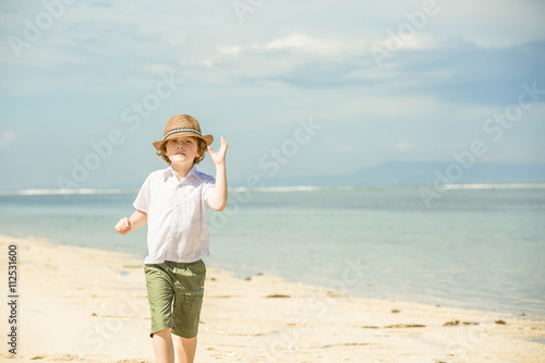Happy caucasian boy enjoing summer on tropical beach
