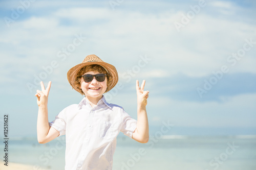 Happy caucasian boy enjoing summer on tropical beach