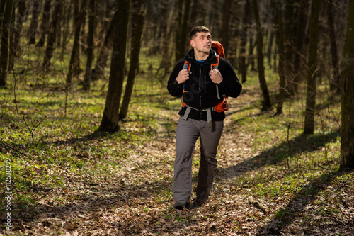 Man using hiking sticks poles outdoors in woods. © Aleksey