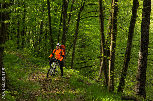 Man bikes in the green forest