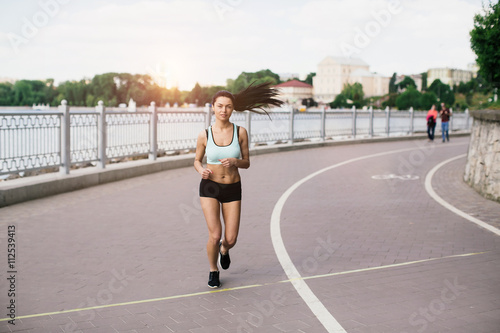 Sexy sports girl runs in park and listening to music © anatoliycherkas